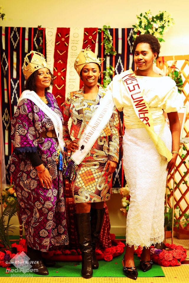 Ambassadrice et lauréates devant un décor en tissus traditionnels.